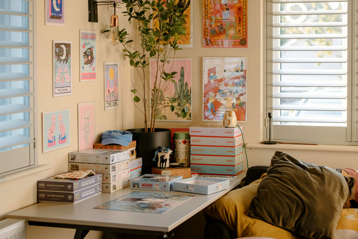 A minimalist and organized home office desk decluttered with green potted plants and neatly stacked books.