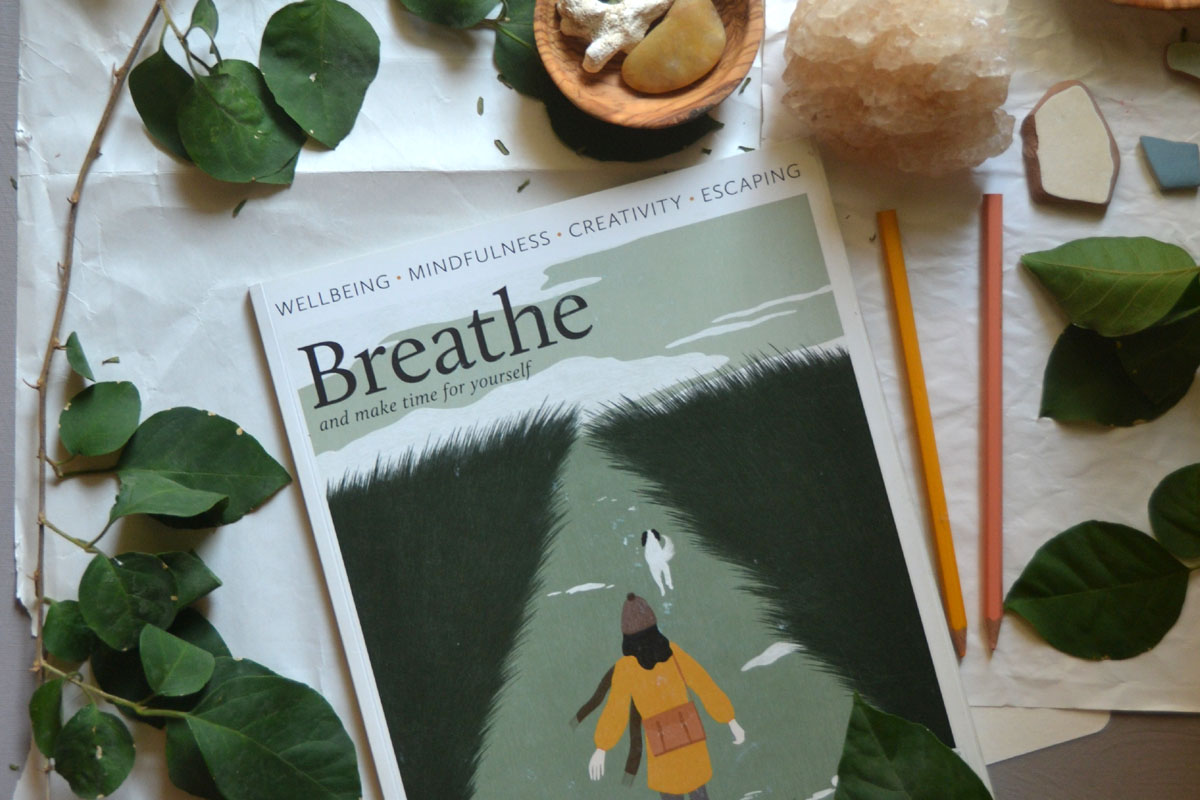 A copy of the print mindfulness magazine Breathe resting on a wooden surface, highlighting analog hobbies and slow living reading materials.