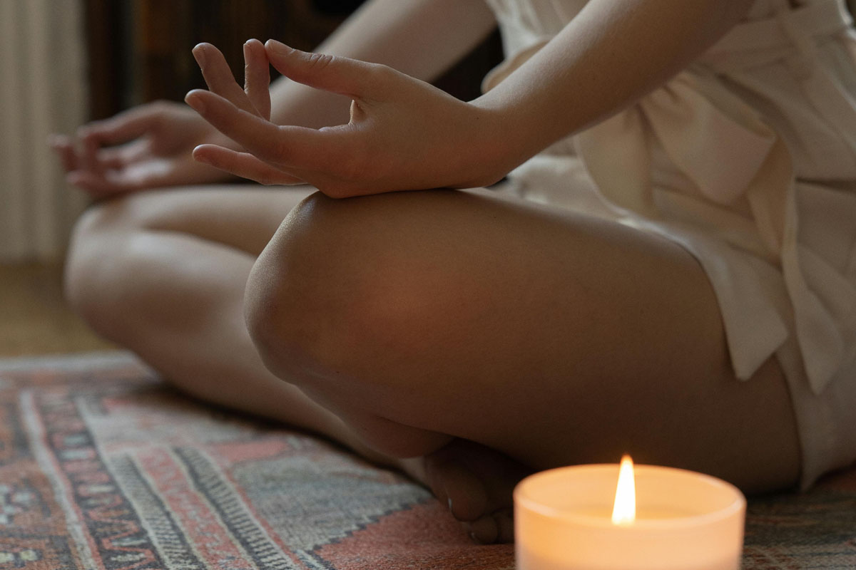 A peaceful, minimalist meditation corner with floor cushions, a glowing salt lamp, and soft lighting for quiet mindfulness.