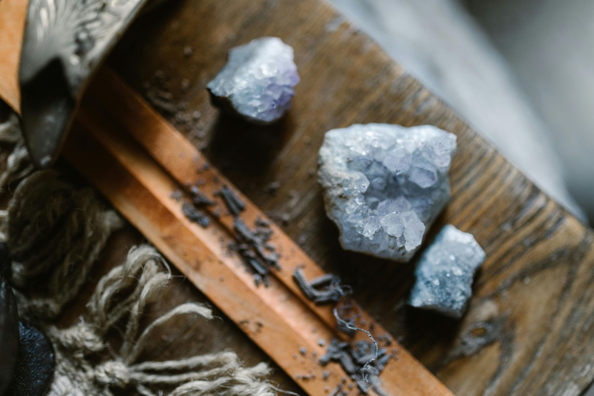 An assortment of raw crystals, including amethyst, charging on a windowsill under full moon lunar energy.