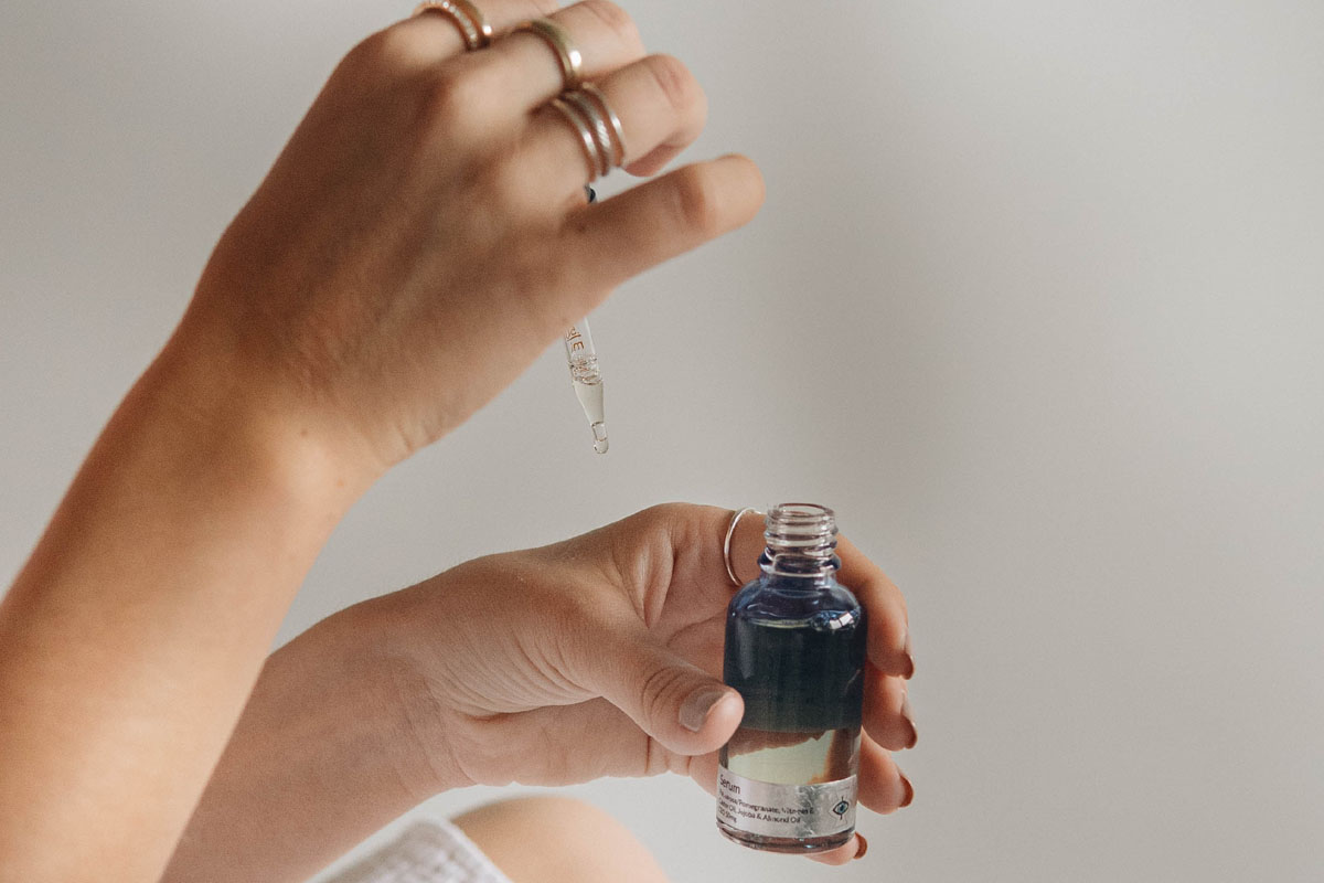 A woman applies oil to her hands in an example of marketing.