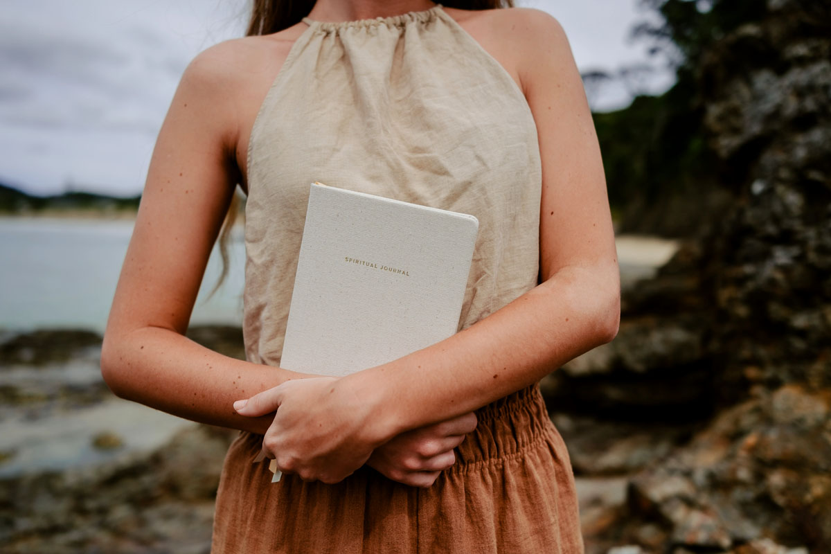 A woman holds a journal in her arms. 