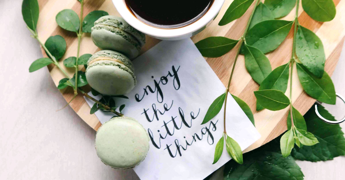 A quote lays on a desk next to coffee and some greenery.