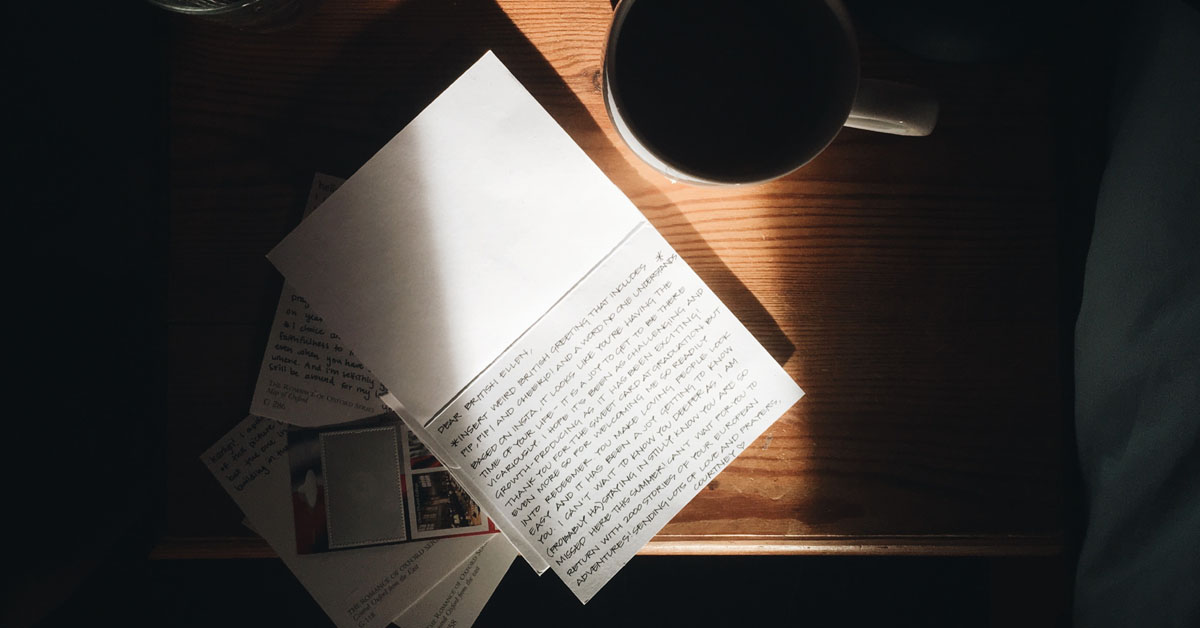 A notebook lays on a sunny desk in an example of a journaling session for mental health benefits.