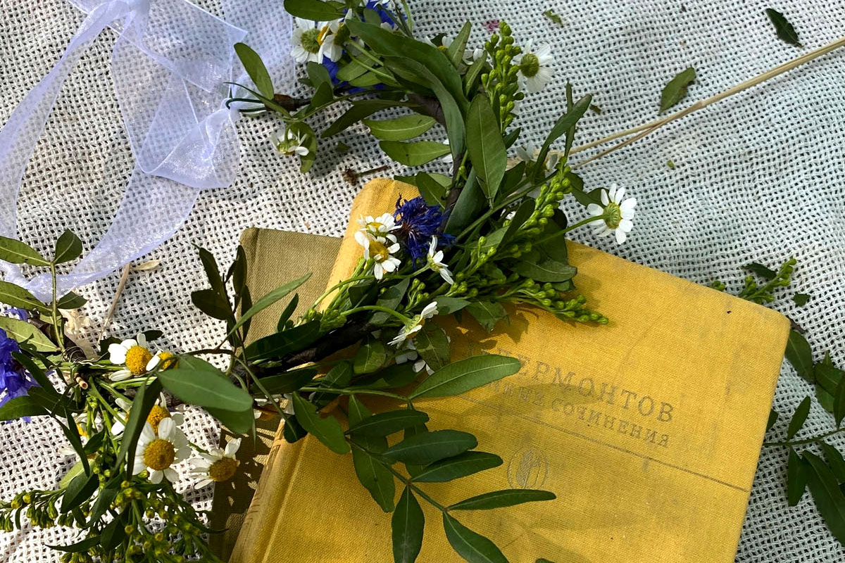 A yellow book with flowers lays on a blanket.