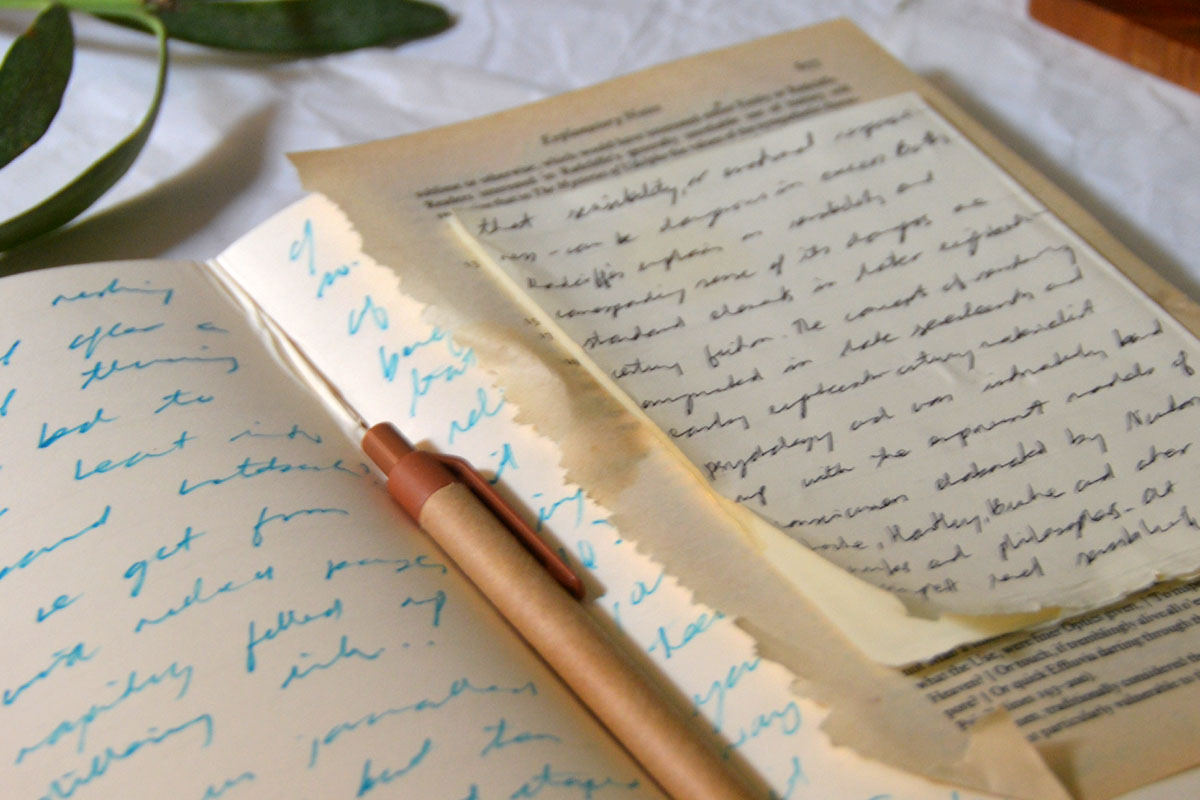A journal with handwriting lays on a table. 