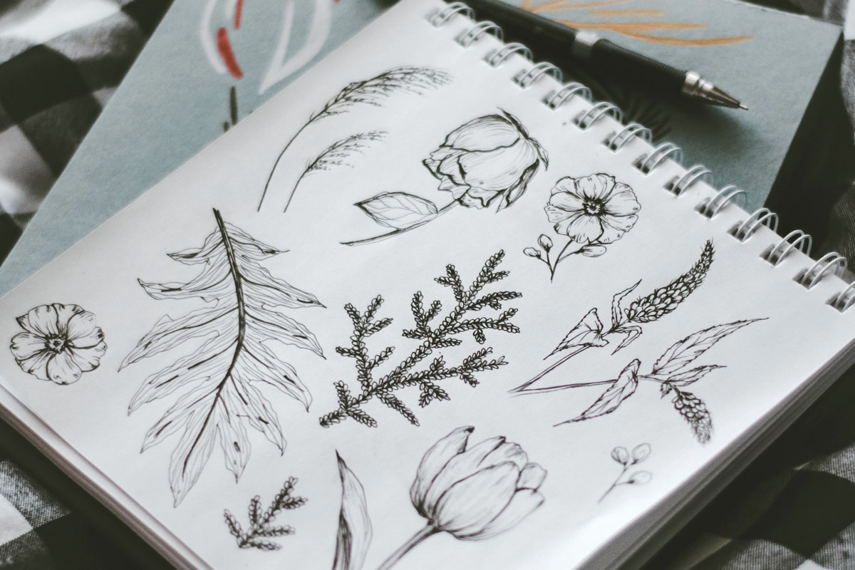 A diary lays open with some doodles of flowers inside.