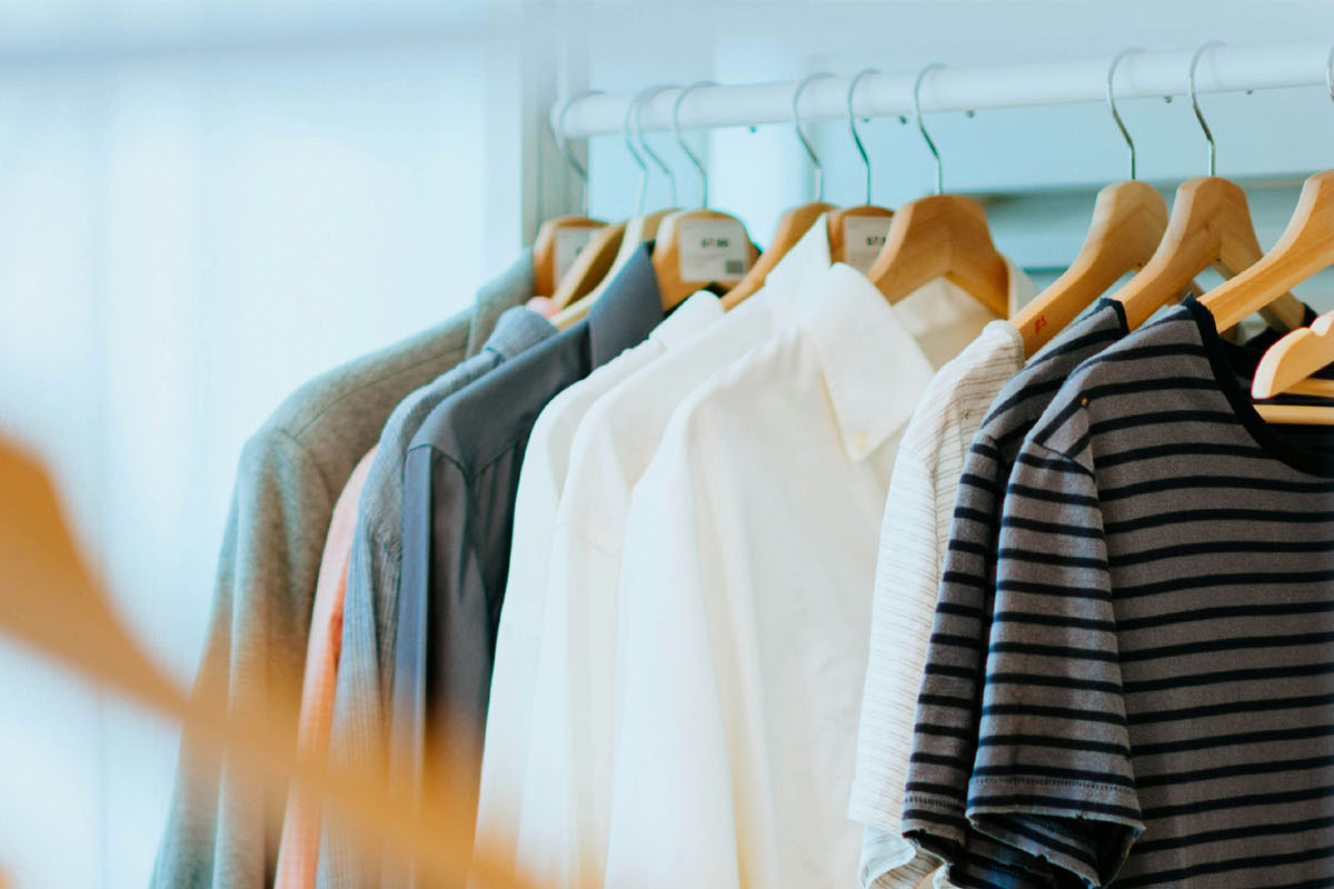 Clothes hang in a well organized closet.