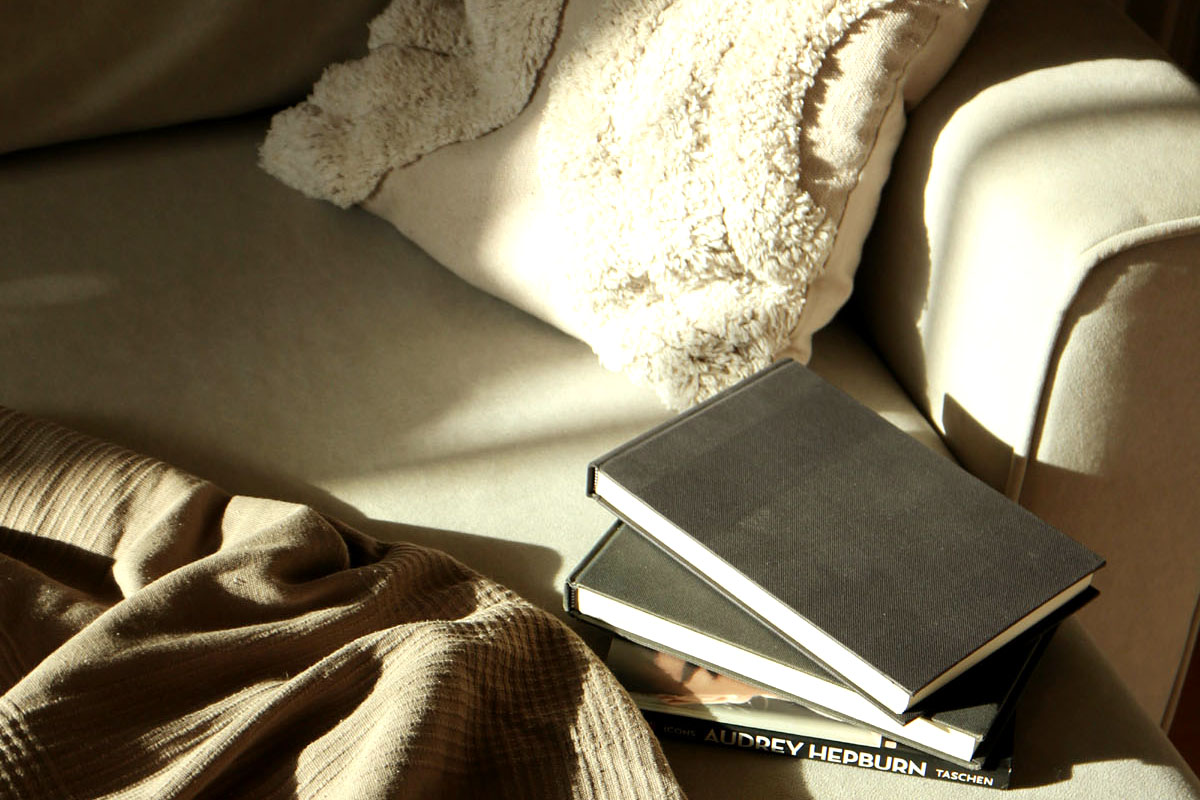 A journal lays on a bed in the sunshine. 