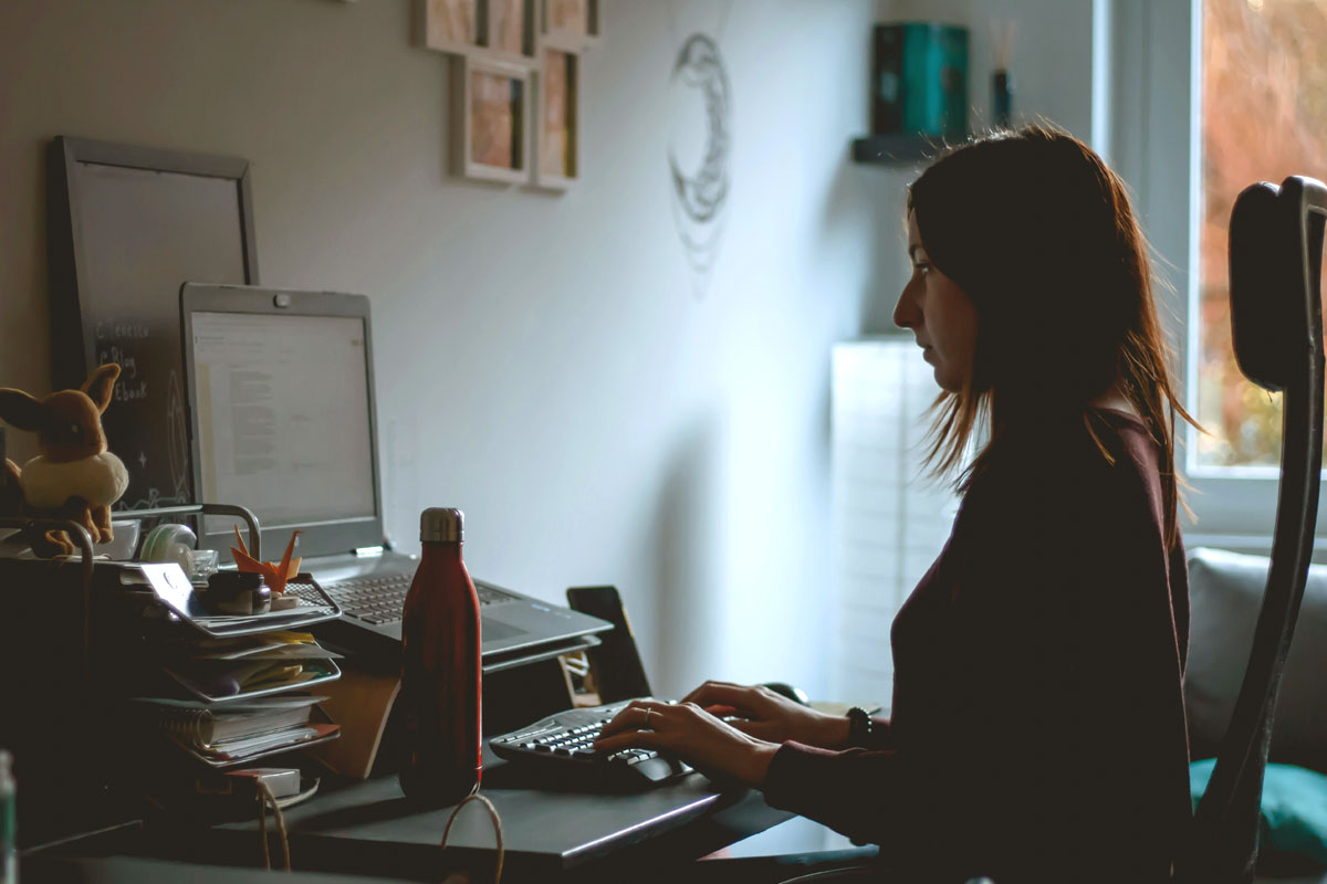 A woman sits at her laptop and writes during NaNoWriMo in November. 