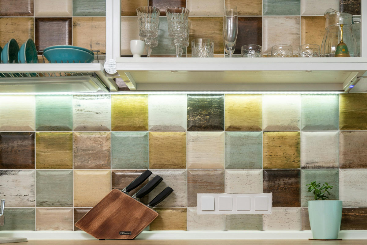 A spotless kitchen counter lined with cups and knives. 