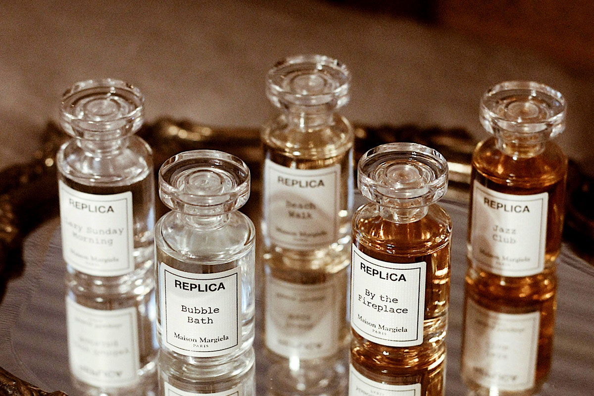 A mirror tray holds several different bottles of Replica perfume.