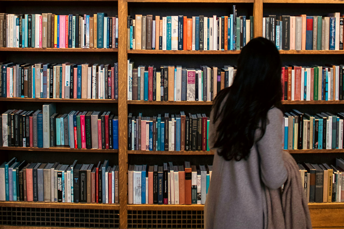 A woman browses shelves filled with books.