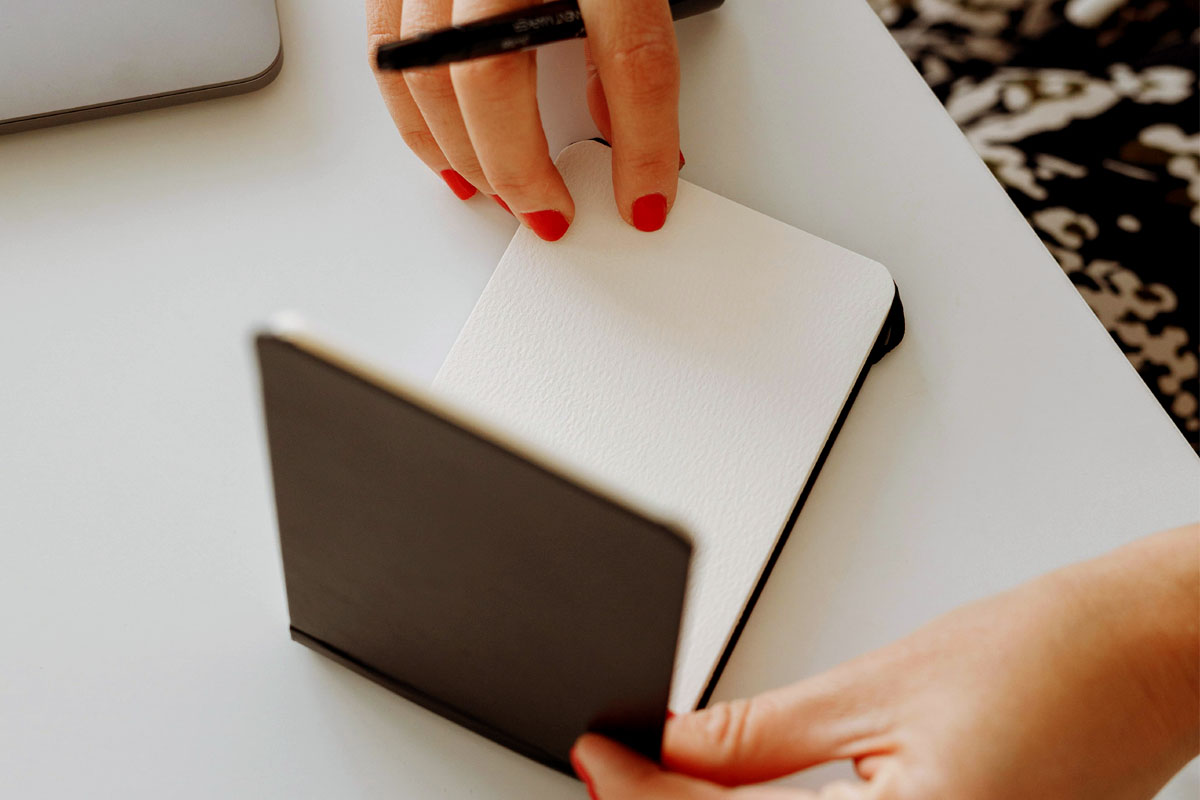 A woman flips open the page in an empty calendar. 