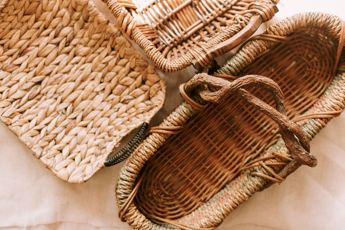 Straw baskets lay on a beige table. 
