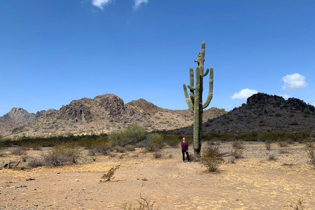 Dee stands next to a Saguaro cactus during a hike in the Phoenix Mountains.