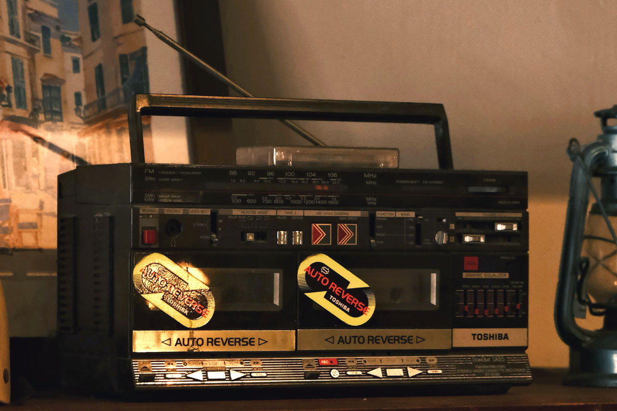 An old radio from the 90s sits on a wooden desk.