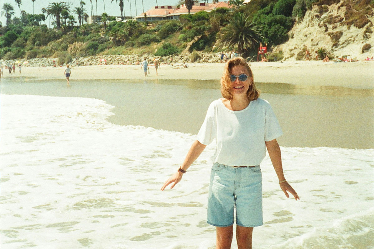 A gen x girl from the 90s enjoying the analog life on the beach without a phone.