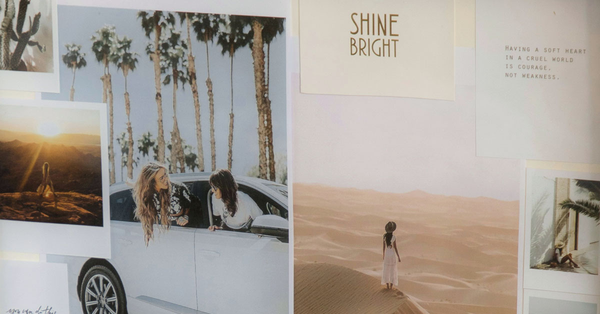 A vision board hangs on a wall filled with pictures of travel and female friendships.
